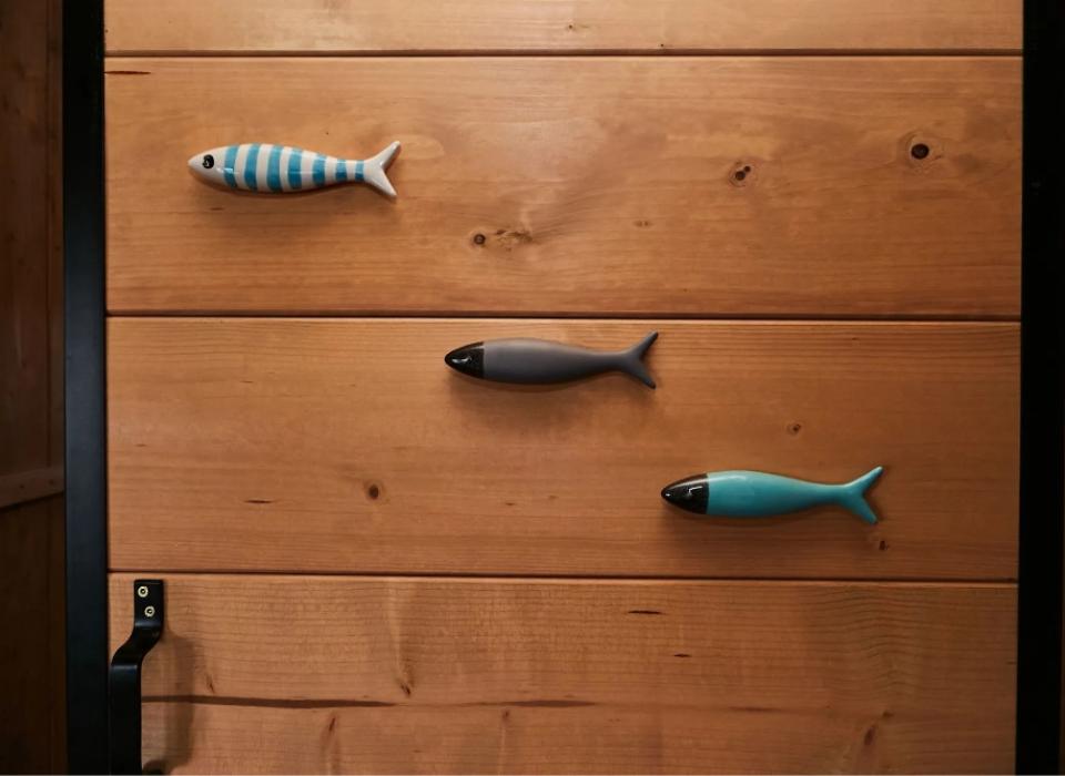 Maniglie a forma di pesce su una porta di legno.