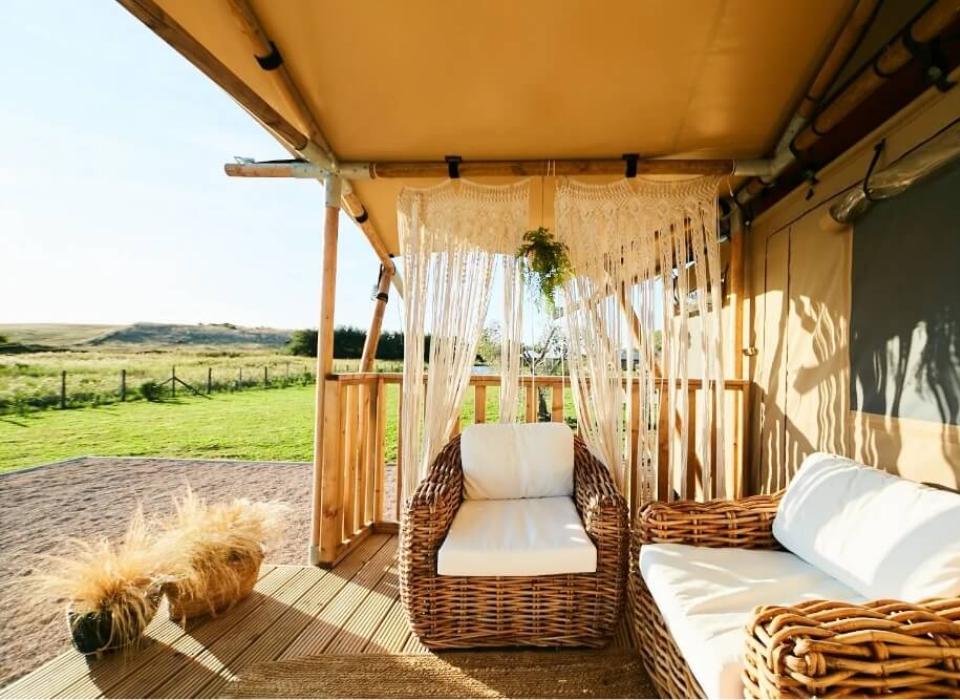 Terrazza accogliente con mobili in rattan e vista panoramica sulla campagna.