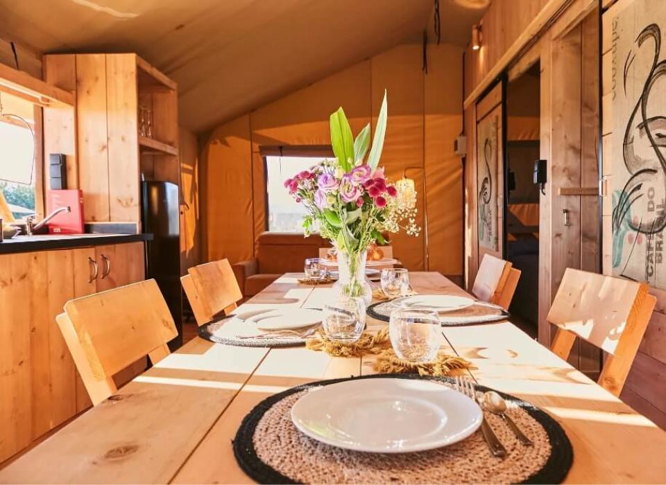 Interno accogliente con tavolo in legno, fiori e arredamento rustico.