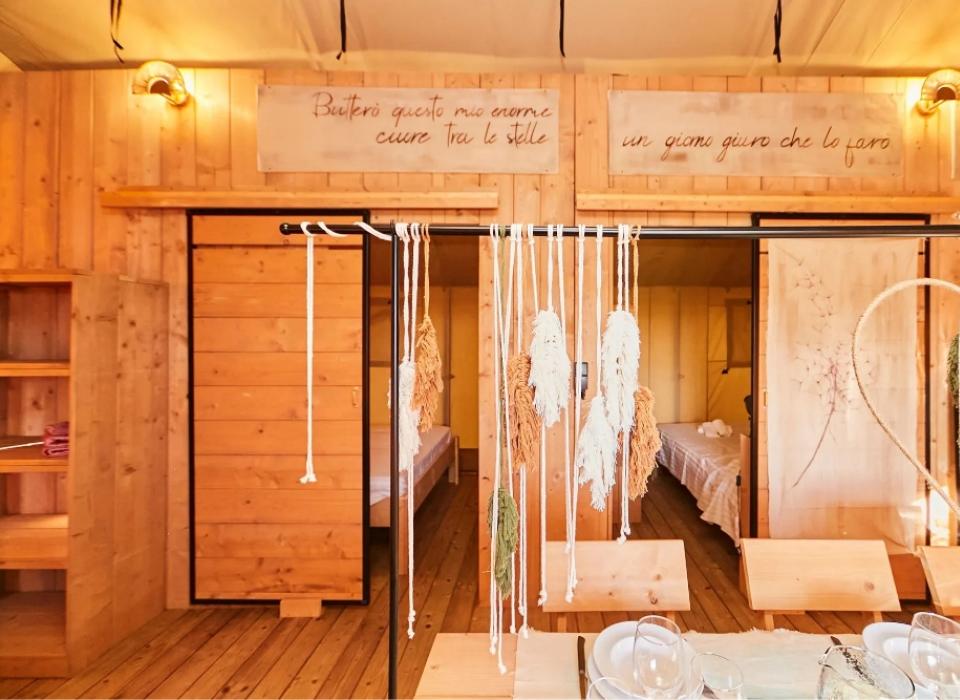 Interno rustico con decorazioni in legno e corde, atmosfera accogliente e calda.