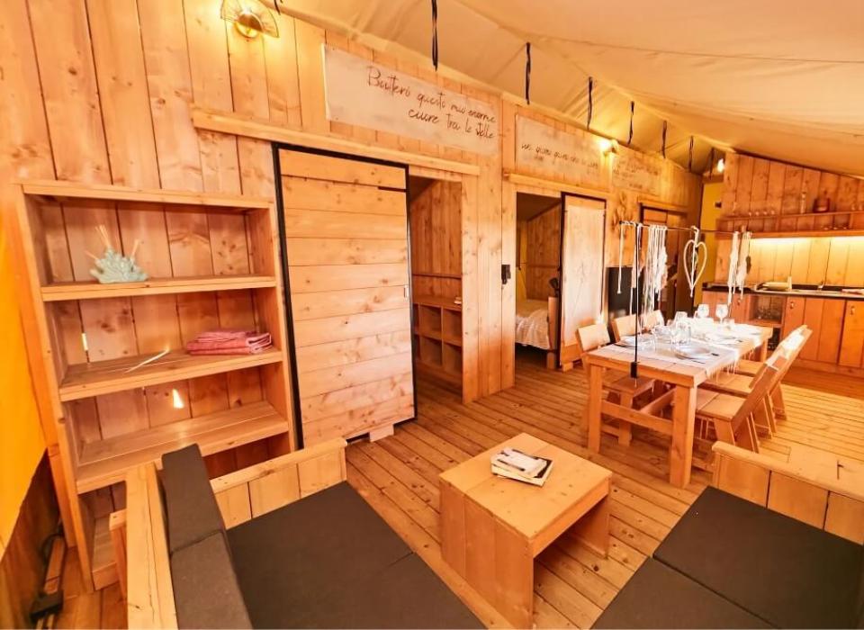 Interno accogliente in legno con cucina, tavolo da pranzo e soggiorno.